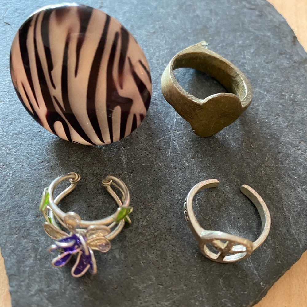 Four costume jewelry rings.